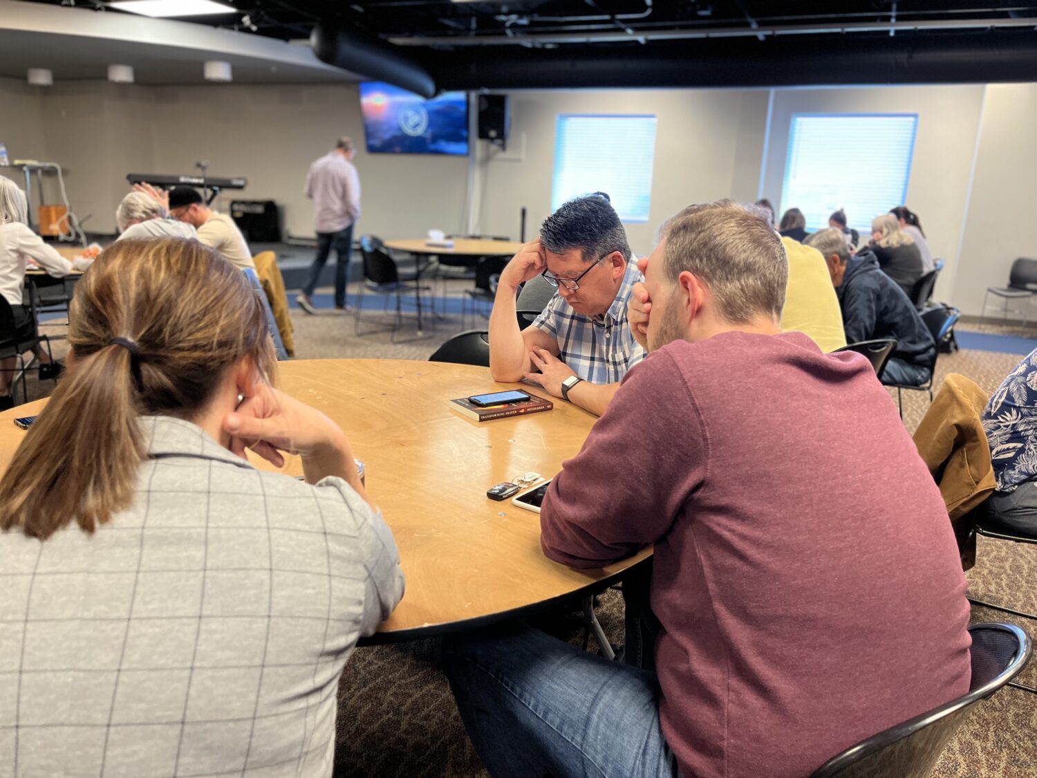 Church members praying around table