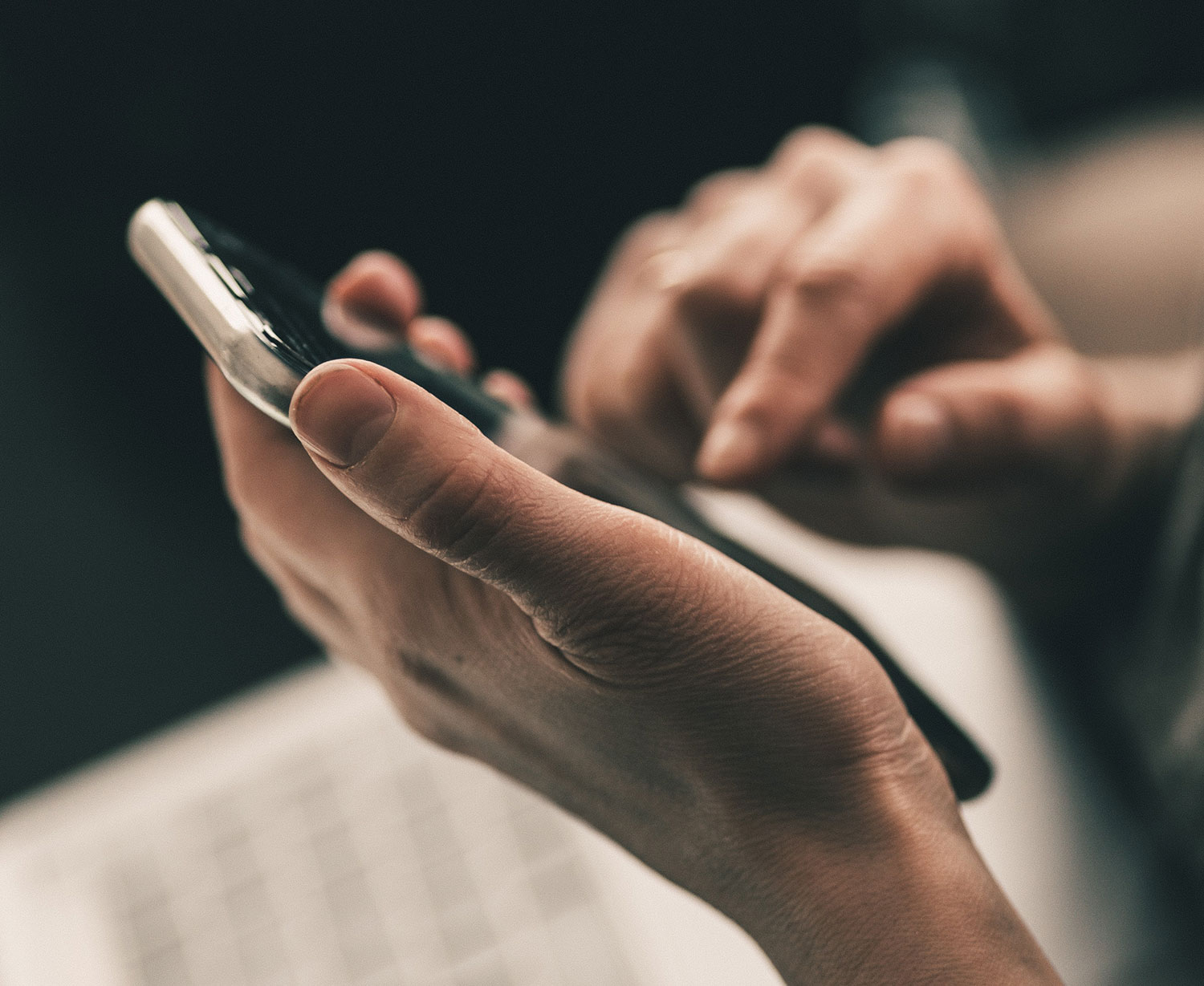 Hands dialing a mobile phone